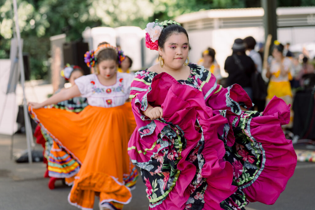 Girl performing a traditional cultural dance, posing gracefully with expressive hand and body movements.